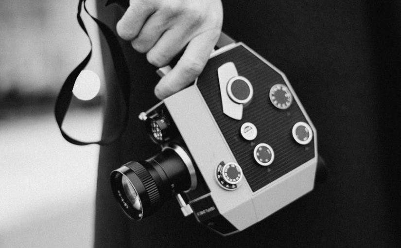 grayscale photo of person holding camera